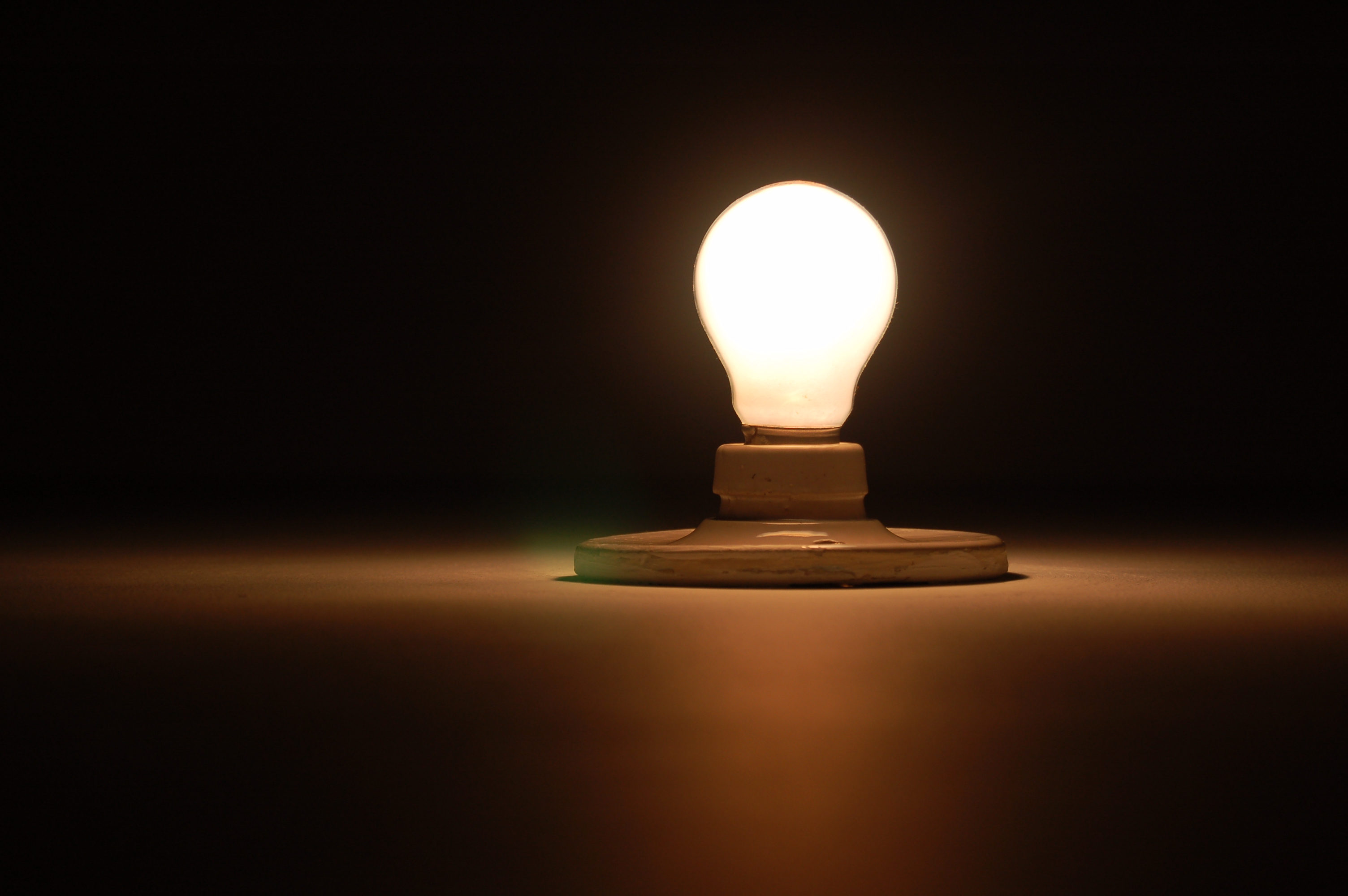 Shining lightbulb in a dark room