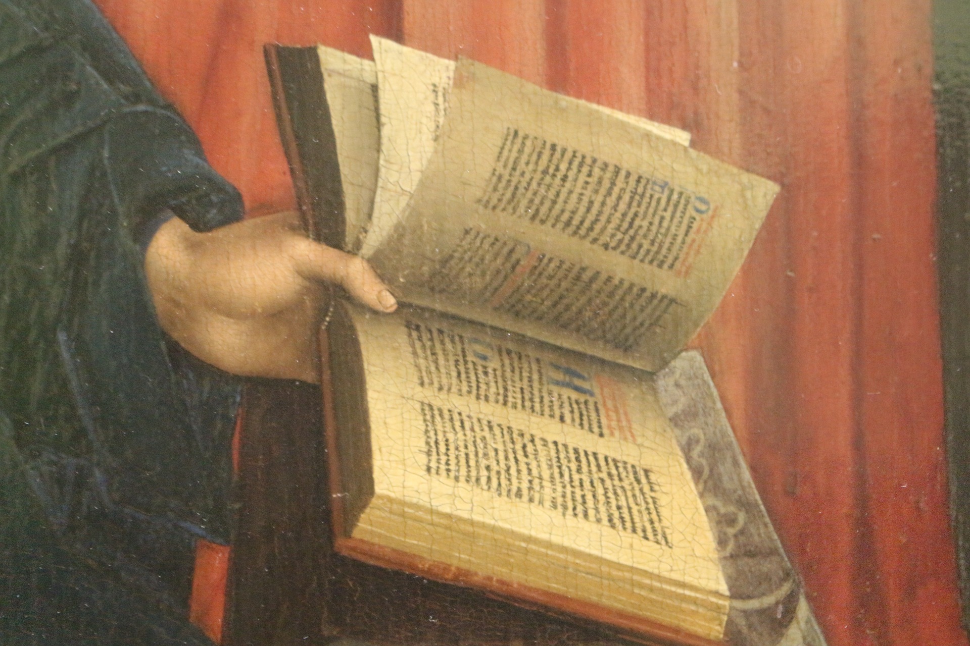 Historical art showcasing a hand holding a book